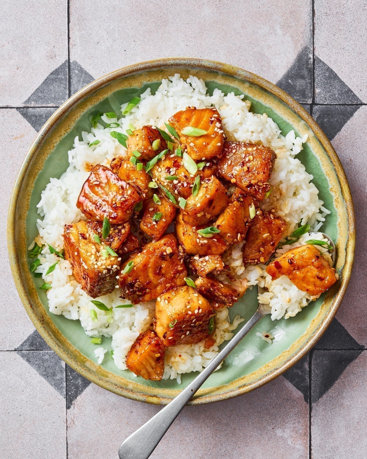 Crispy honey garlic salmon bites glazed with sesame seeds and spring onions