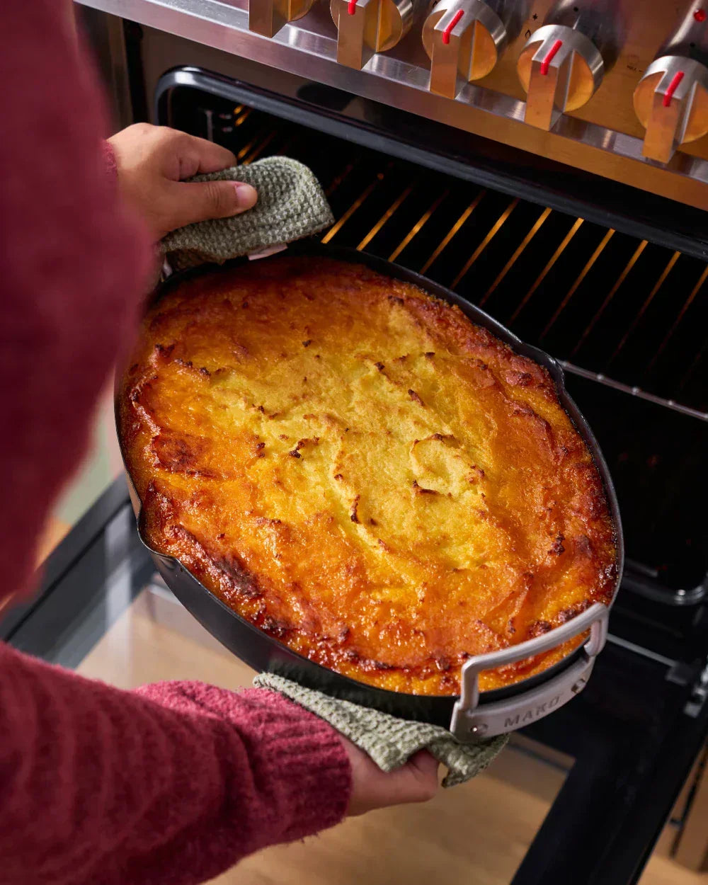 Homemade shepherd’s pie in a black MAKO pan being taken out of the oven