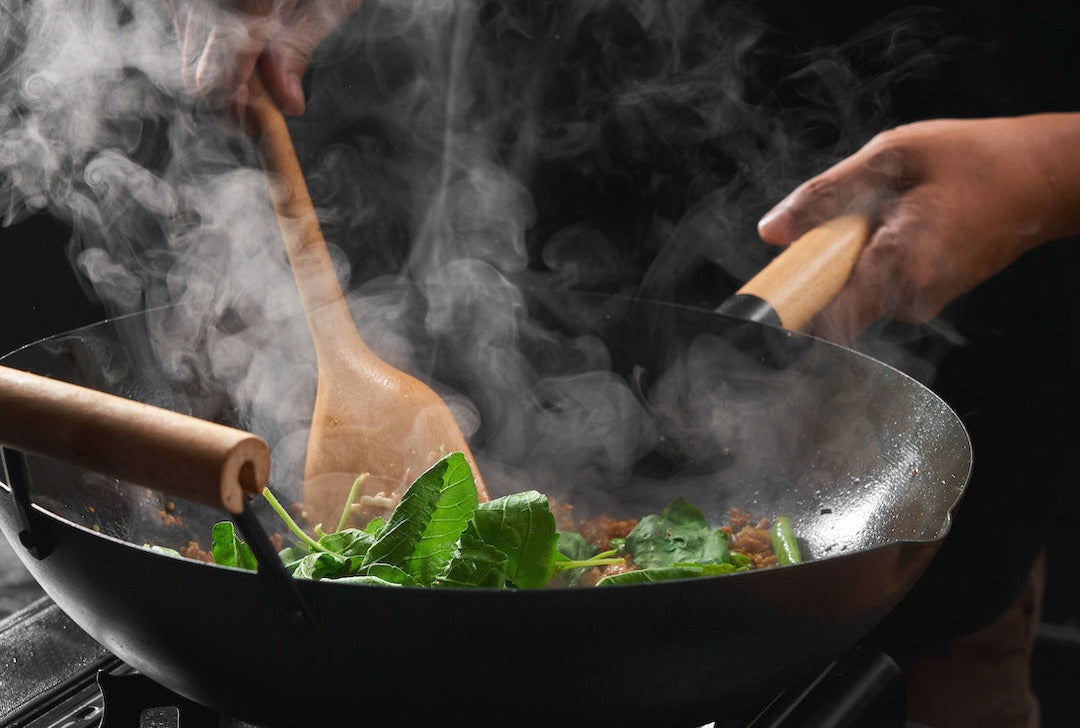 Black Carbon Steel Wok in use on gas smoking hot Wok hei Breath of the wok CookDineHost