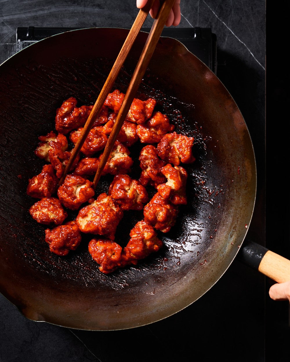 Korean fried chicken cooking in a wok with wooden chopsticks, Mako cookware by Marion Grasby on CookDineHost