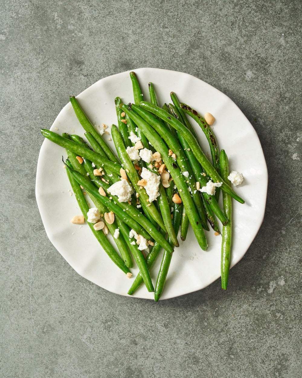 Grilled green beans with crumbled cheese and chopped nuts on a white Asoke ceramic plate by Marion Grasby