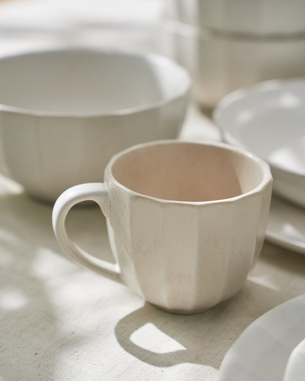 Matte ceramic mug and bowls in a natural light kitchen setting, modern homewares