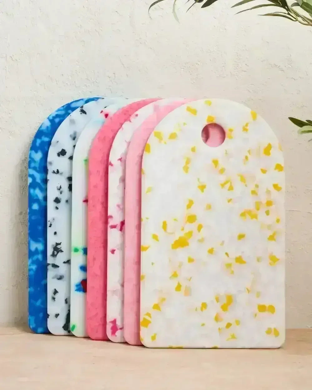 Colorful terrazzo-patterned cutting boards standing upright on a kitchen surface