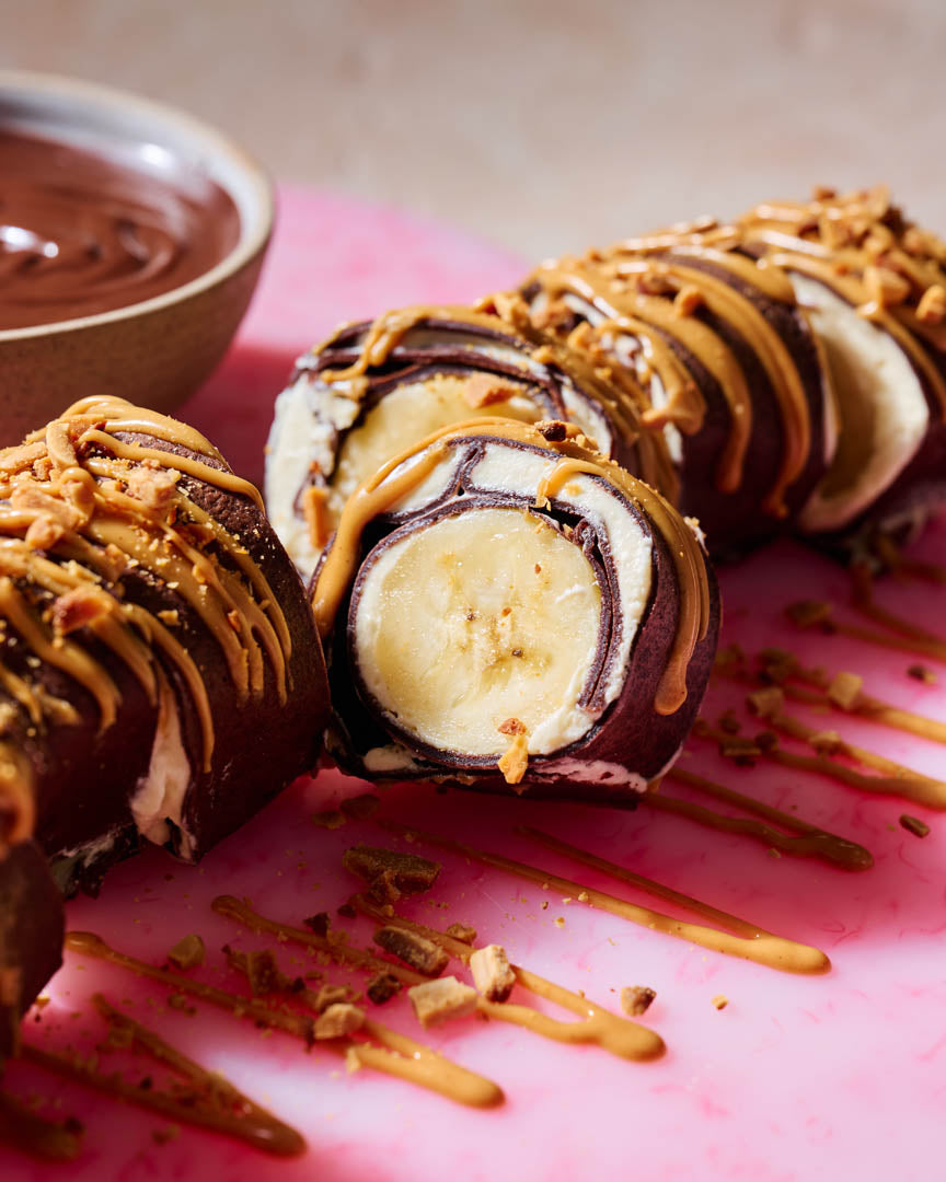 Chocolate crepe roll filled with cream, strawberries and banana