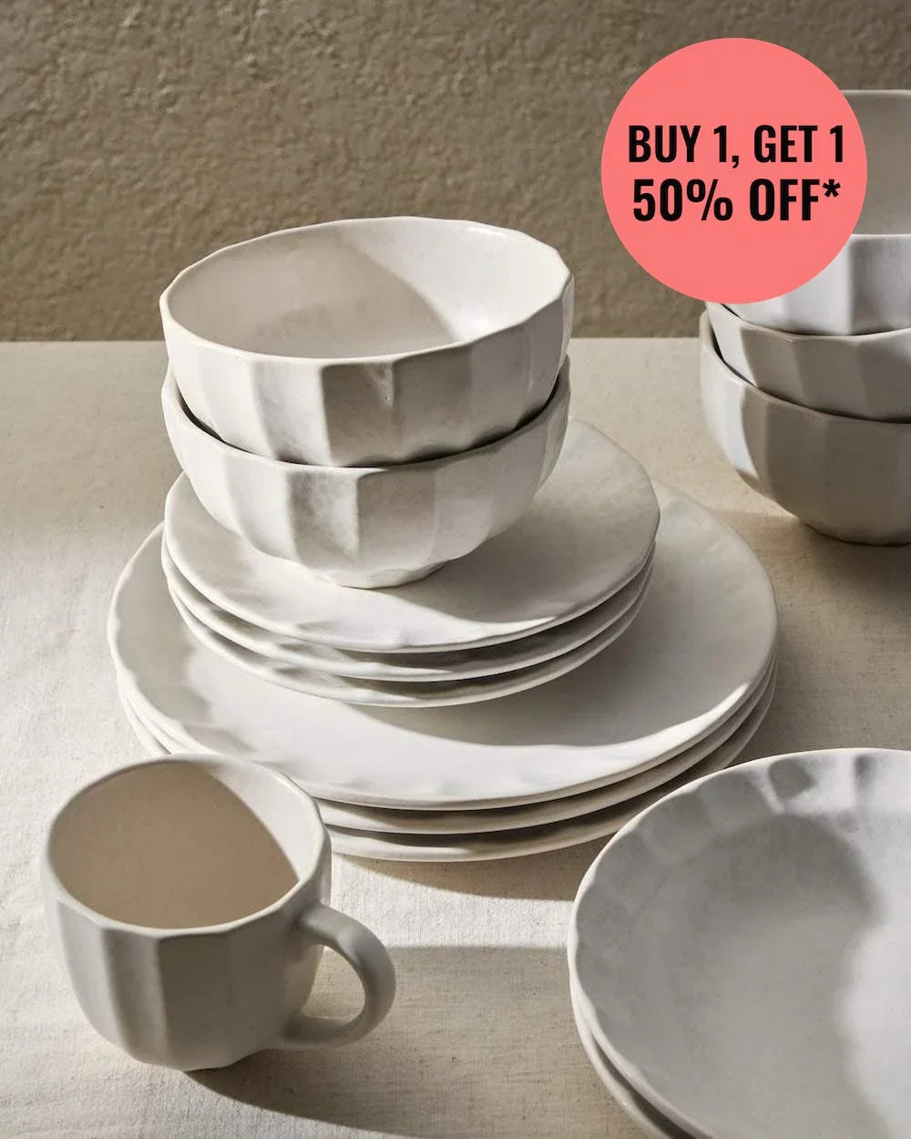 Calida 24-piece white dinnerware set with textured bowls, plates, and mugs on beige table