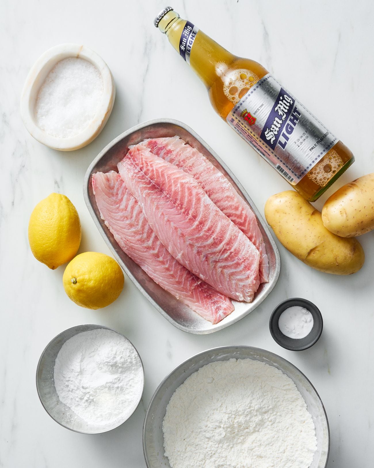 Crispy Beer -Battered Fish and Chips- Recipe CookDineHost recipe ingredients flat lay on marble benchtop