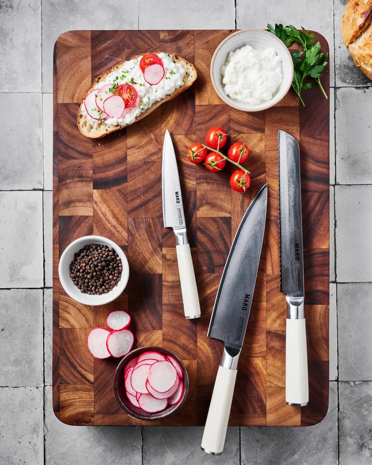 MAKO Japanese Steel Knife Trio - Cream styled shot with trio on wooden chopping board radish cottage cheese tomatoes bread black pepper