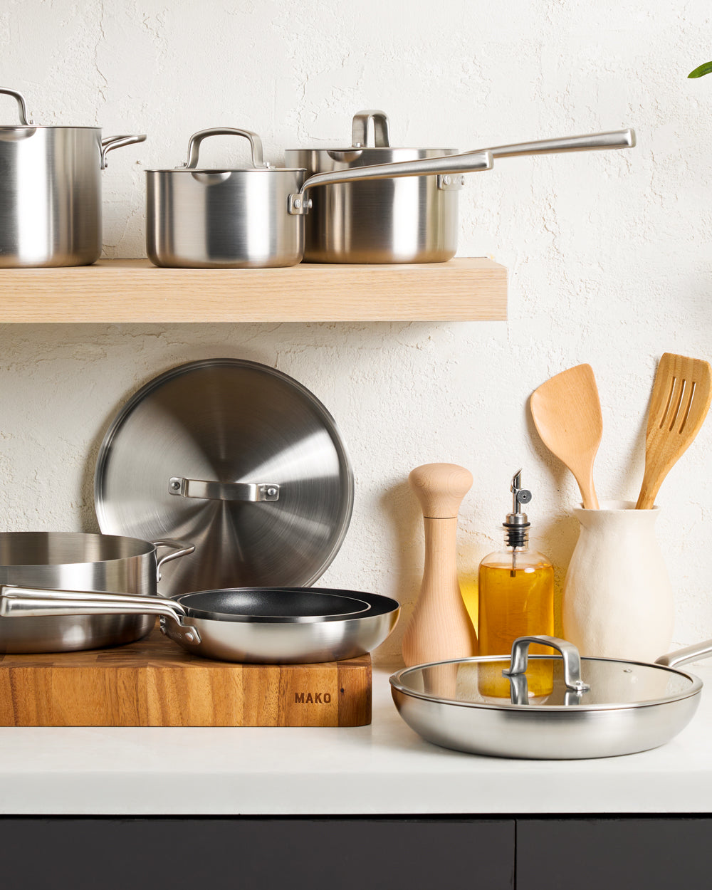 MAKO GENIUS 5-PLY NON-STICK FRYING PAN TRIO with LID - CookDineHost image among other kitchen utensils and pans