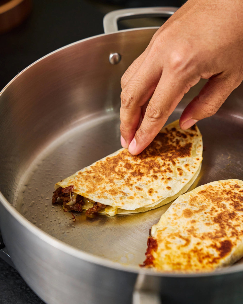 Beef filled tacos crisped on the pan with melted cheese