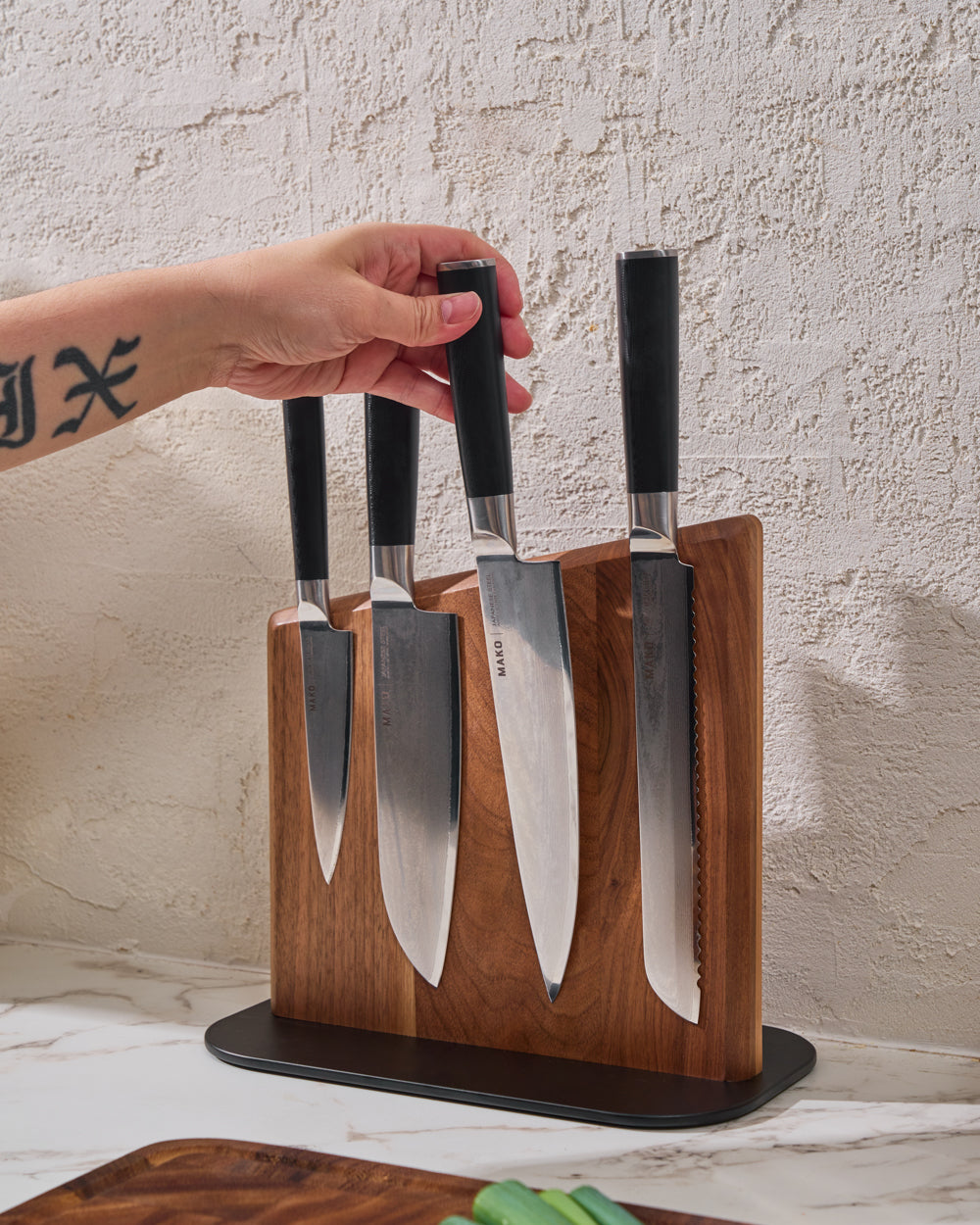 MAKO Magnetic Knife Block on bench-top selecting Chef knife black handles chopping board below
