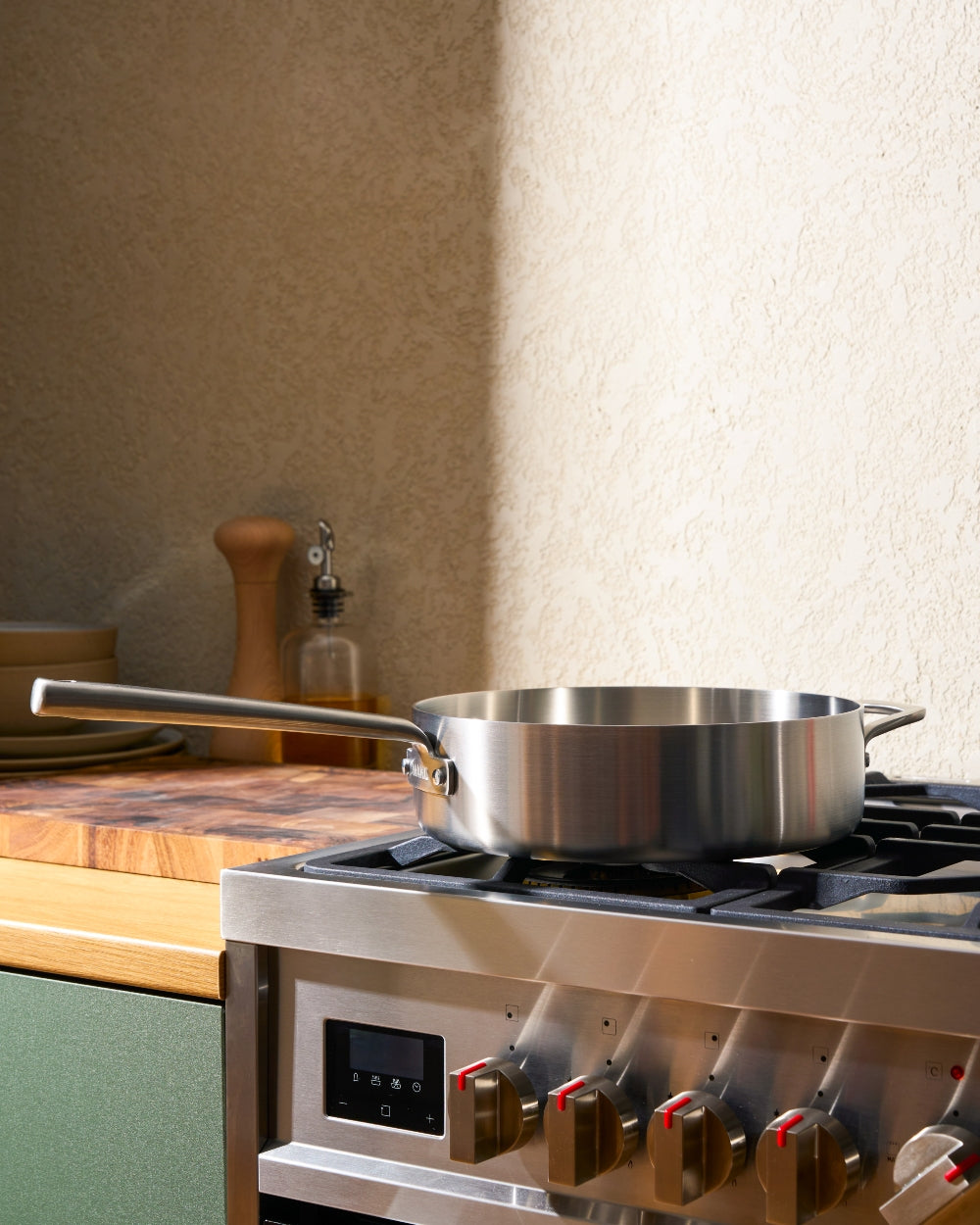 Stainless steel sauté pan on a modern gas stove in a bright kitchen setting