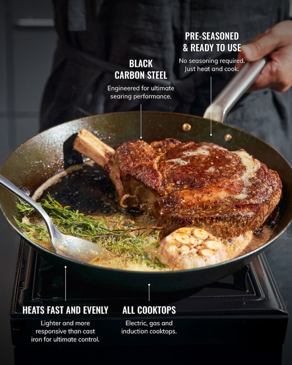 Seared steak with herbs and garlic sizzling in black carbon steel skillet on stovetop