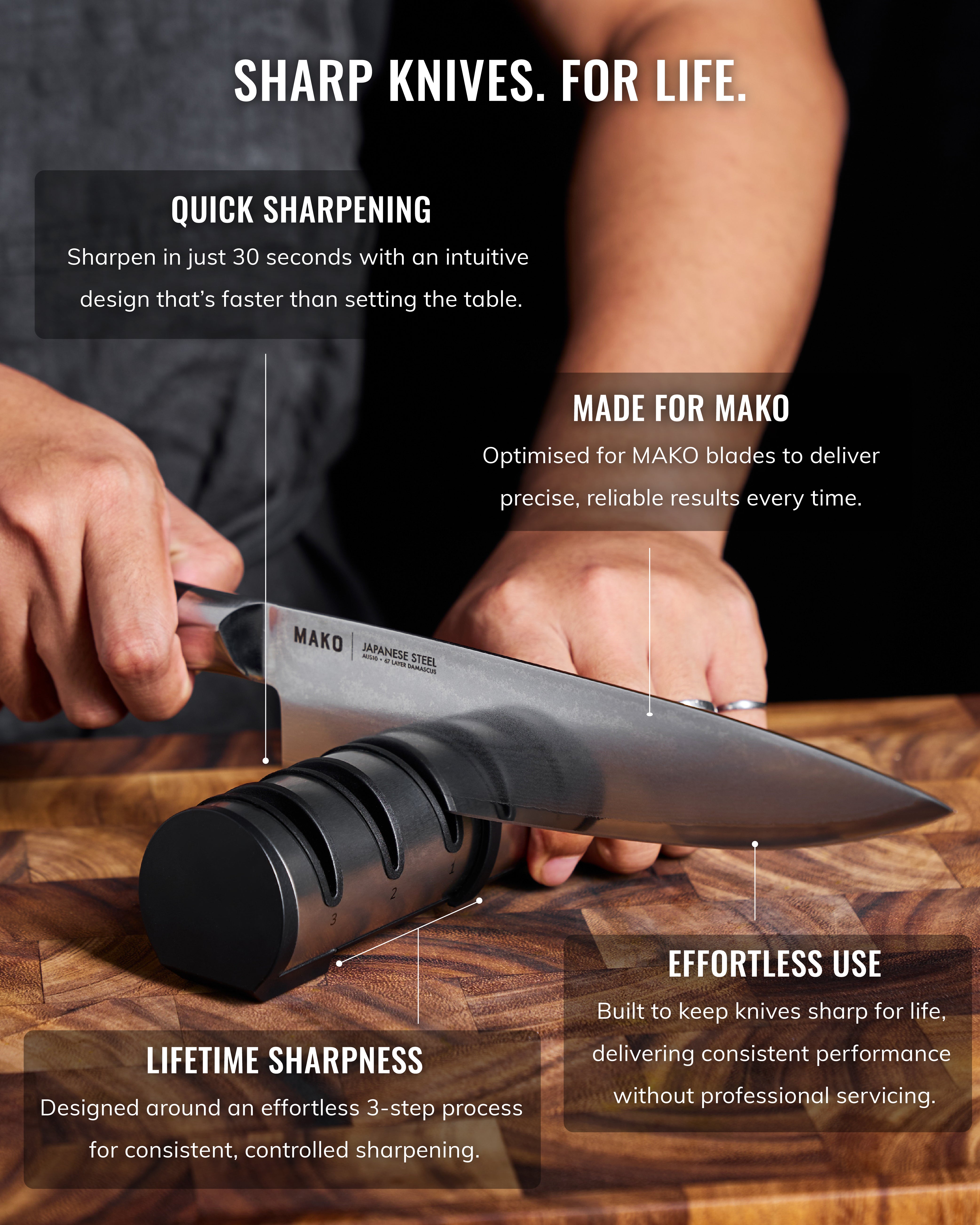 Hand sharpening a Japanese steel kitchen knife with a black knife sharpener on a wooden board.