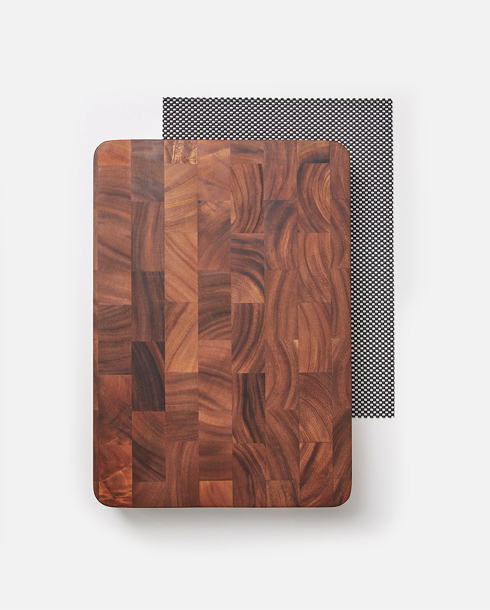 Rectangular wooden butcher block cutting board on non-slip mat, kitchen accessory