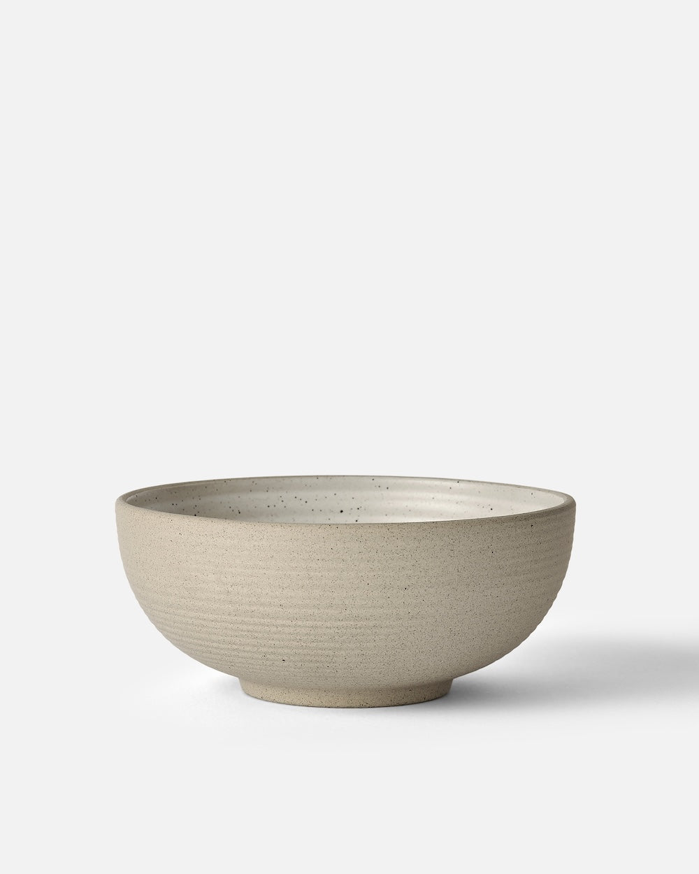 Neutral stoneware cereal bowl with matte speckled finish on white background