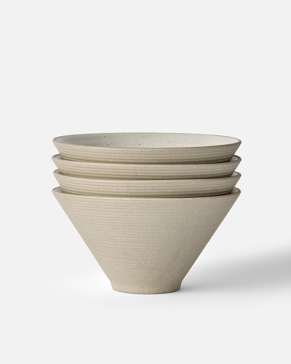 Stacked set of four minimalist beige ceramic noodle bowls on white background