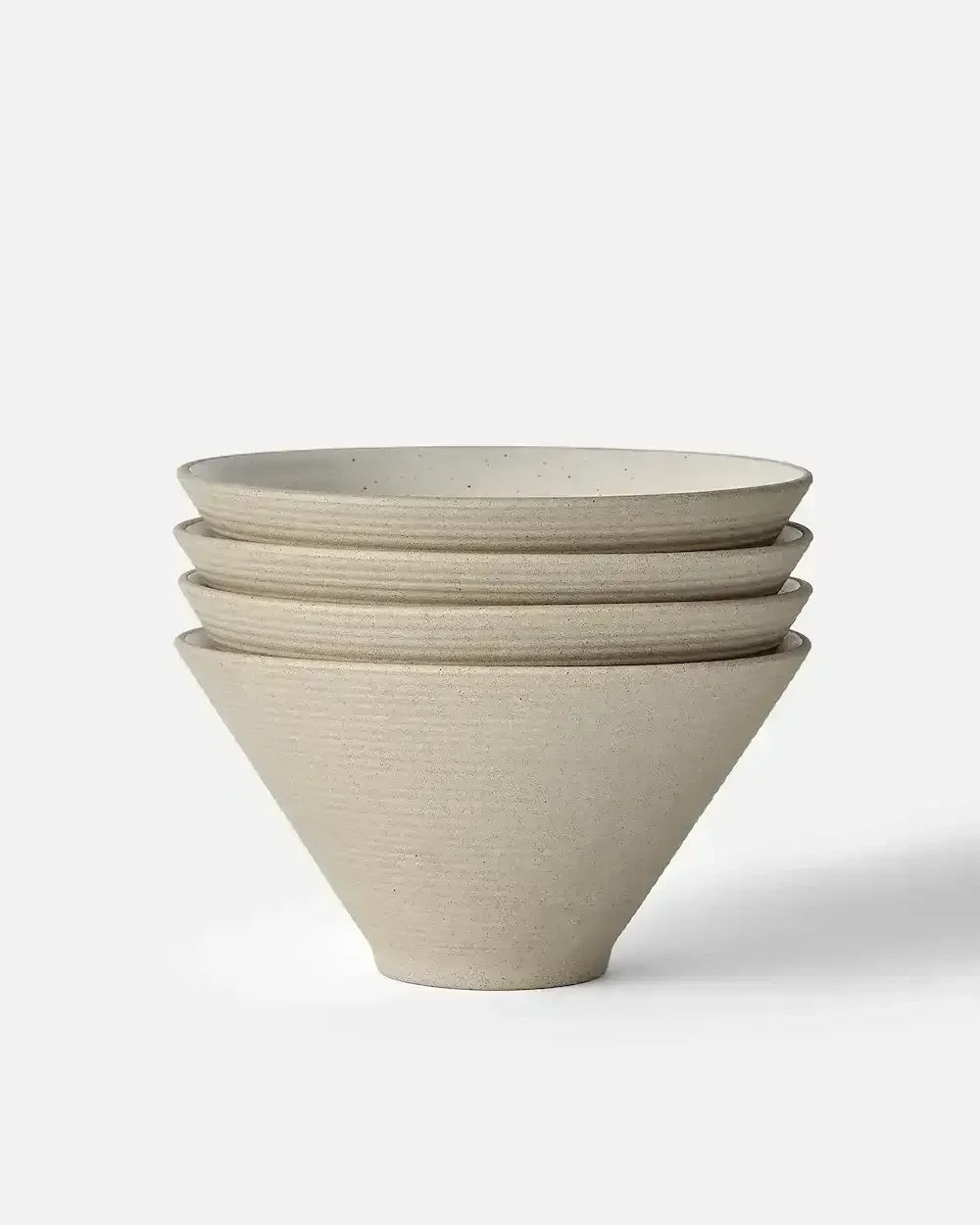 Stacked set of four beige ceramic noodle bowls with a minimalist design on a white background