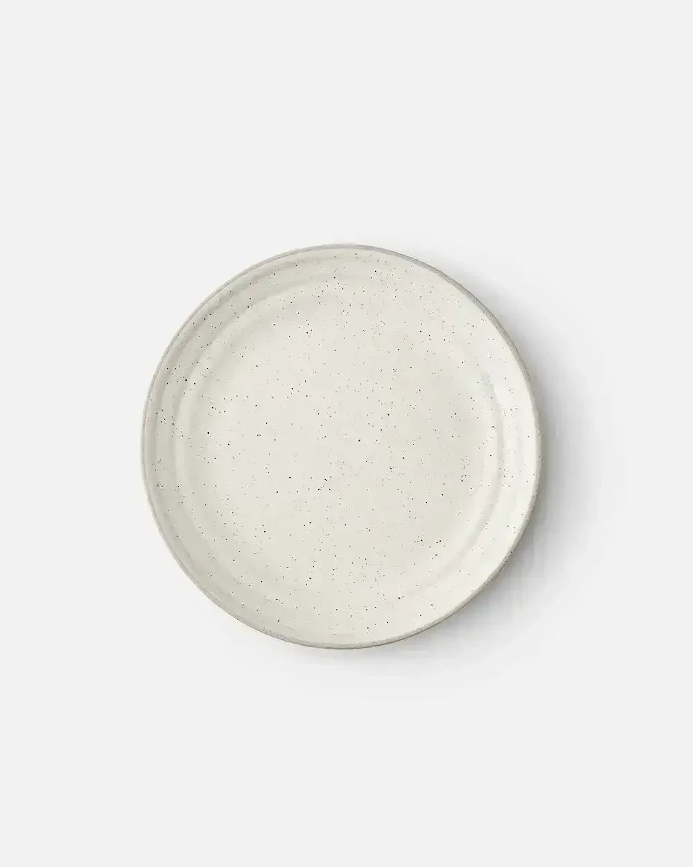 Minimalist stoneware side plate with speckled off-white glaze on white background