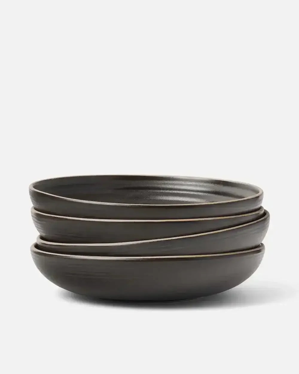 Stacked set of four charcoal wide ceramic bowls on a white background