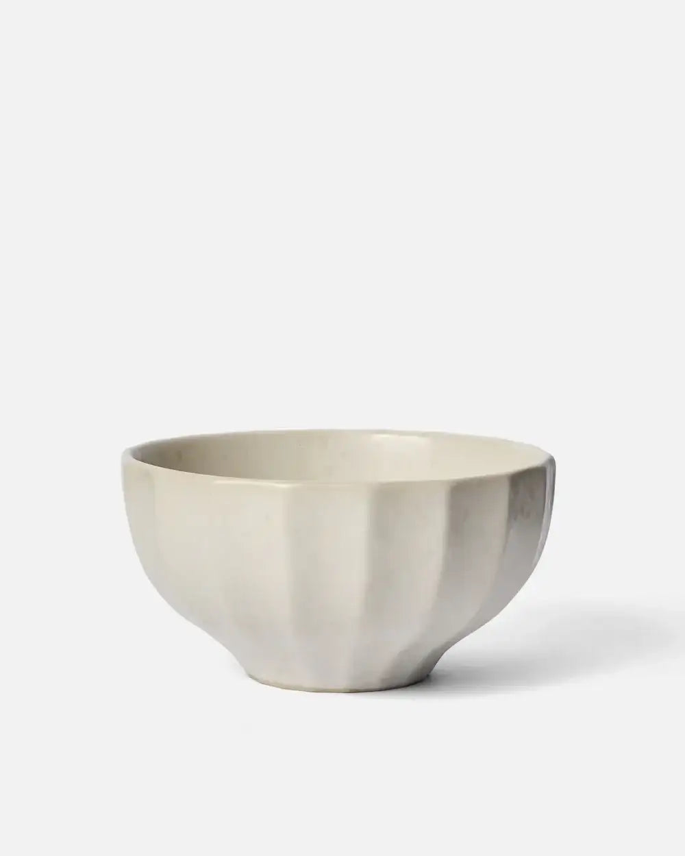 Cream ceramic cereal bowl with fluted design by Marion Grasby against white background