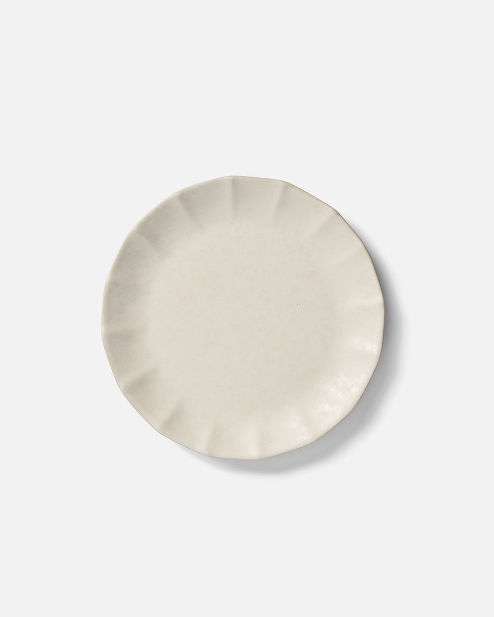 Cream ceramic side plate with textured rim on white background