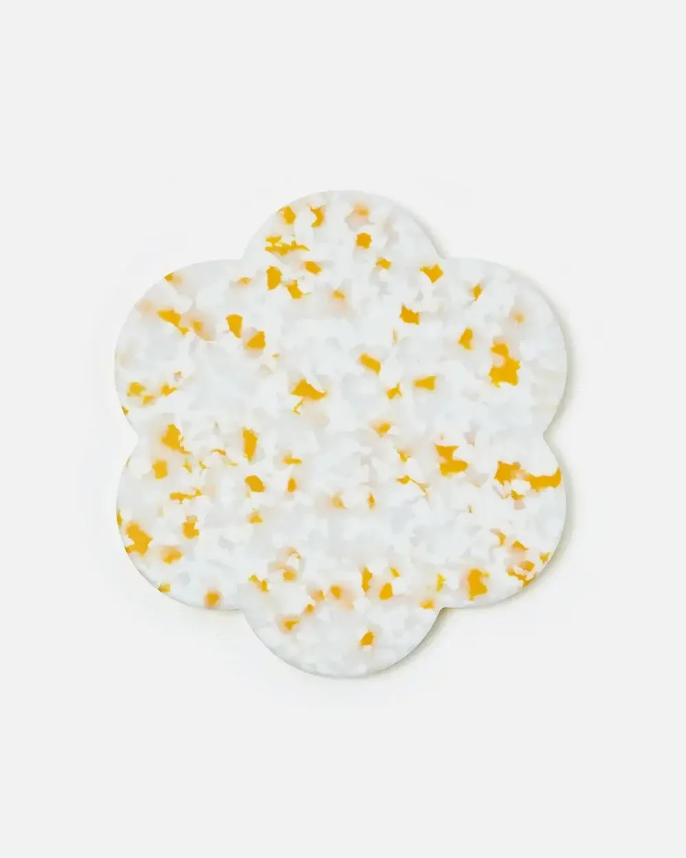 Flower-shaped terrazzo coaster with white and yellow pattern on white background