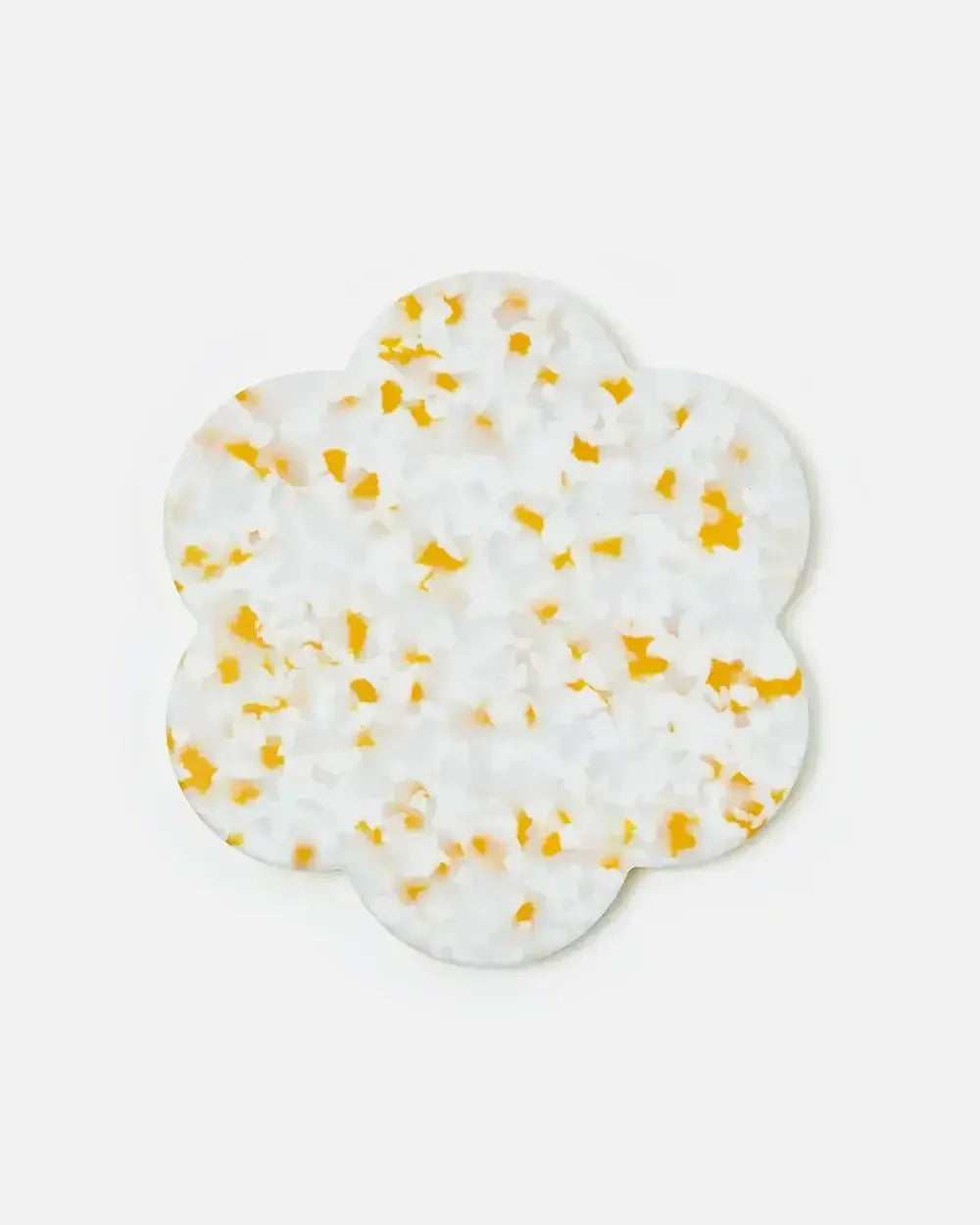 Scalloped white decorative coaster with yellow terrazzo pattern on a plain background.