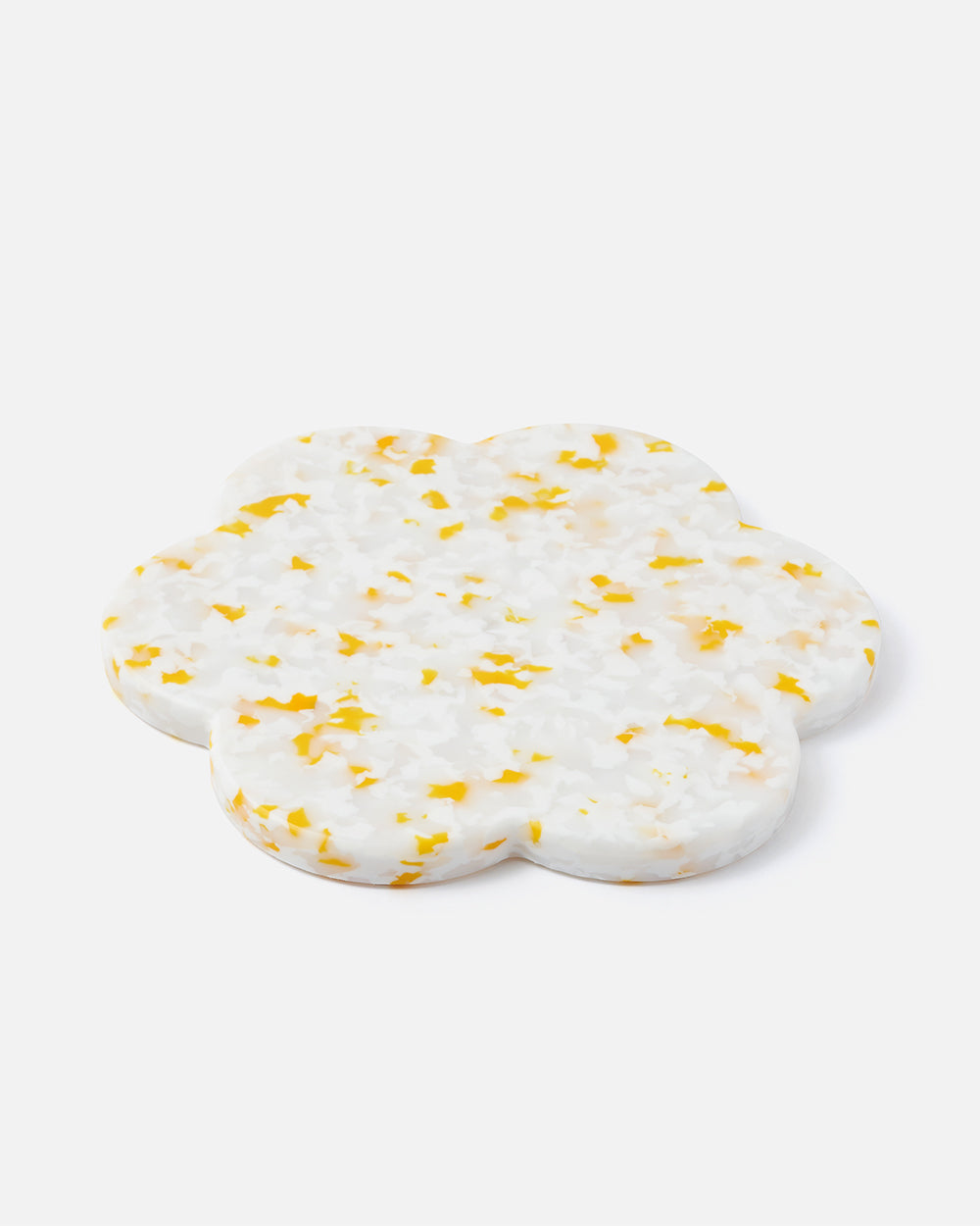 Flower-shaped terrazzo trivet with white base and yellow speckles on white background.
