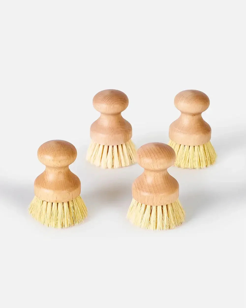Set of four wooden kitchen scrub brushes with natural bristles on a white background