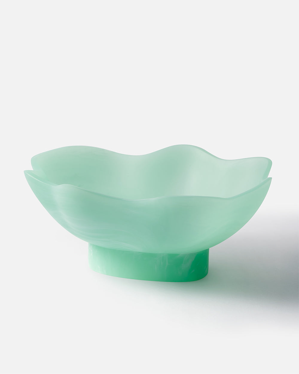 Mint green wavy-edged decorative glass bowl on white background