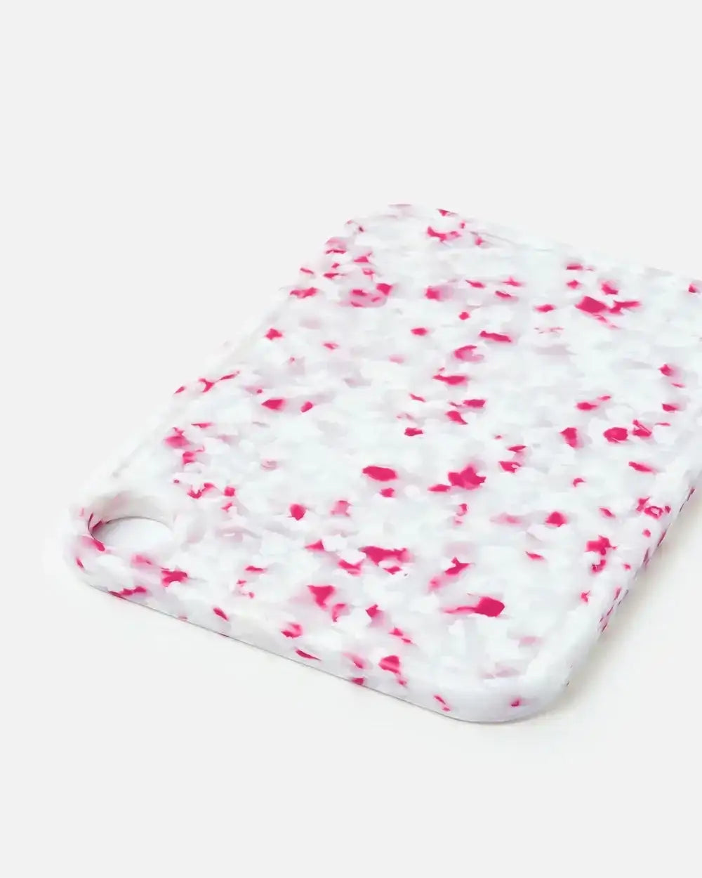White and pink speckled cutting board with a rounded corner hole by Marion Grasby