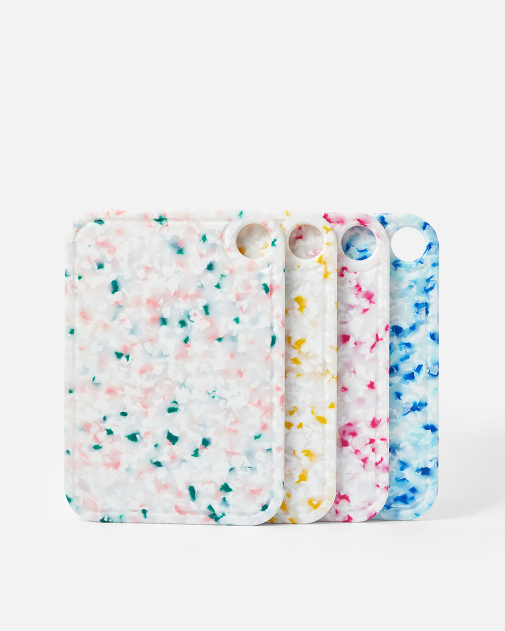 Set of four colorful terrazzo-patterned cutting boards with rounded corners