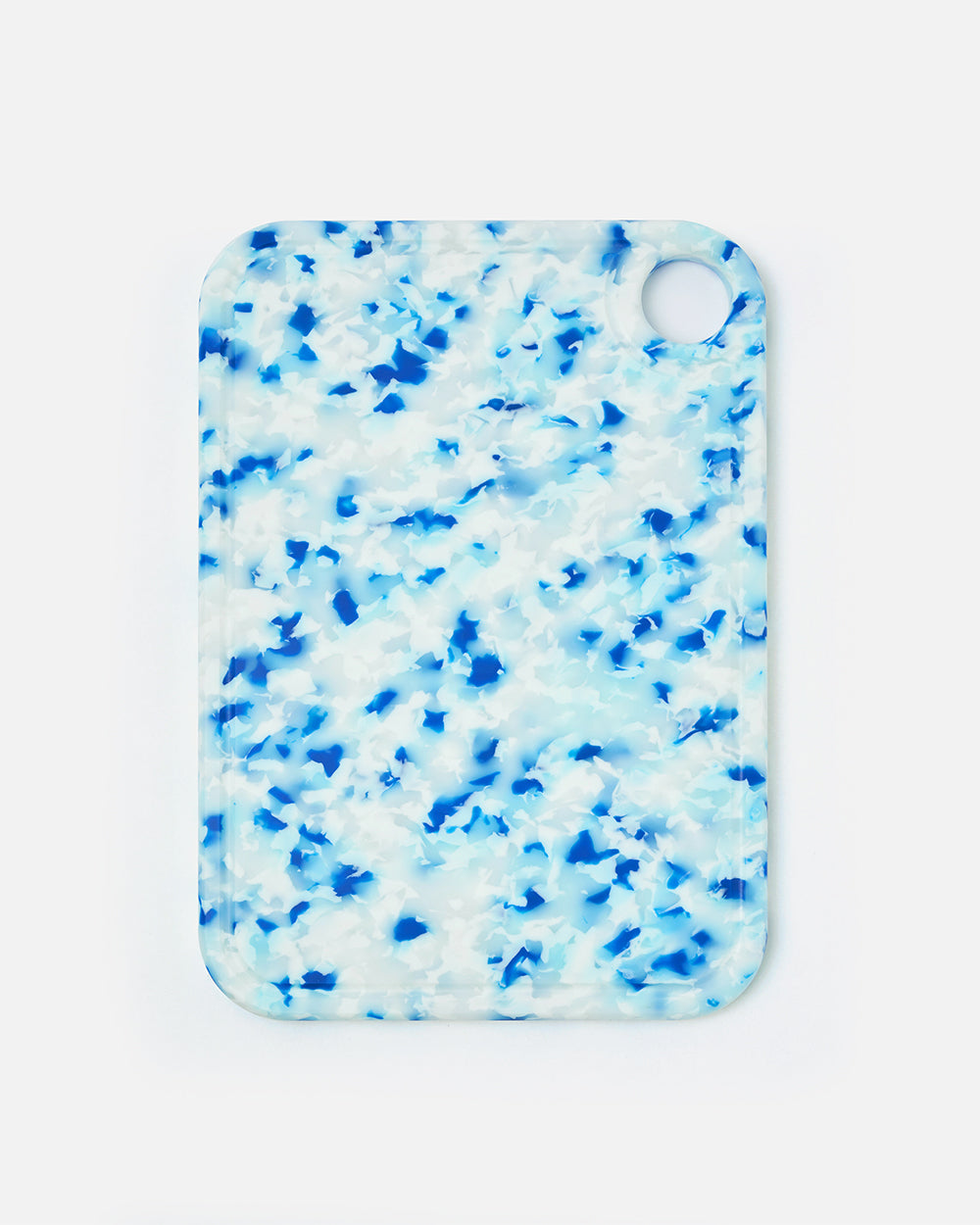 Blue and white speckled cutting board with rounded corners and a handle hole