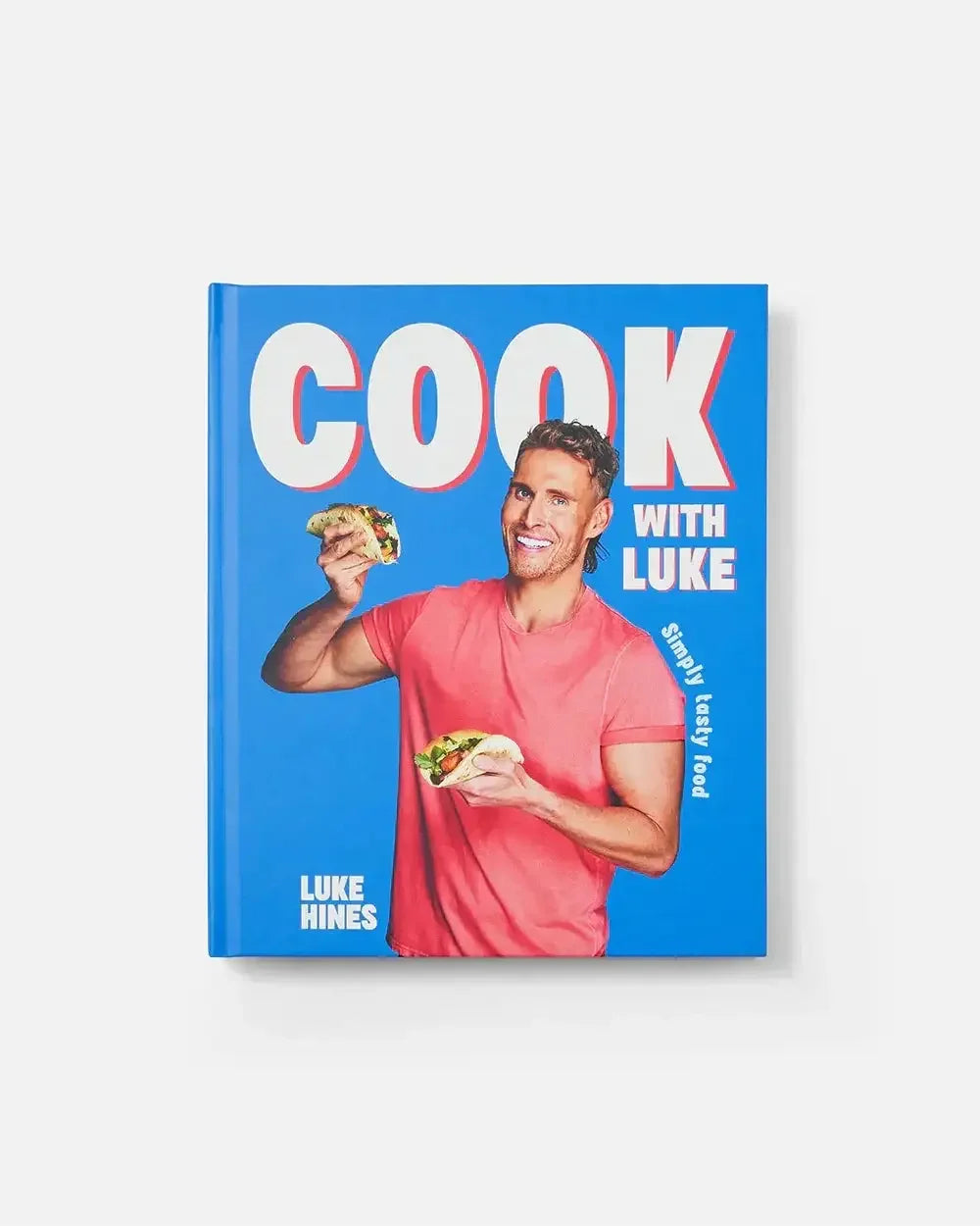 Cookbook cover featuring man in pink shirt holding tacos with bold text COOK WITH LUKE.