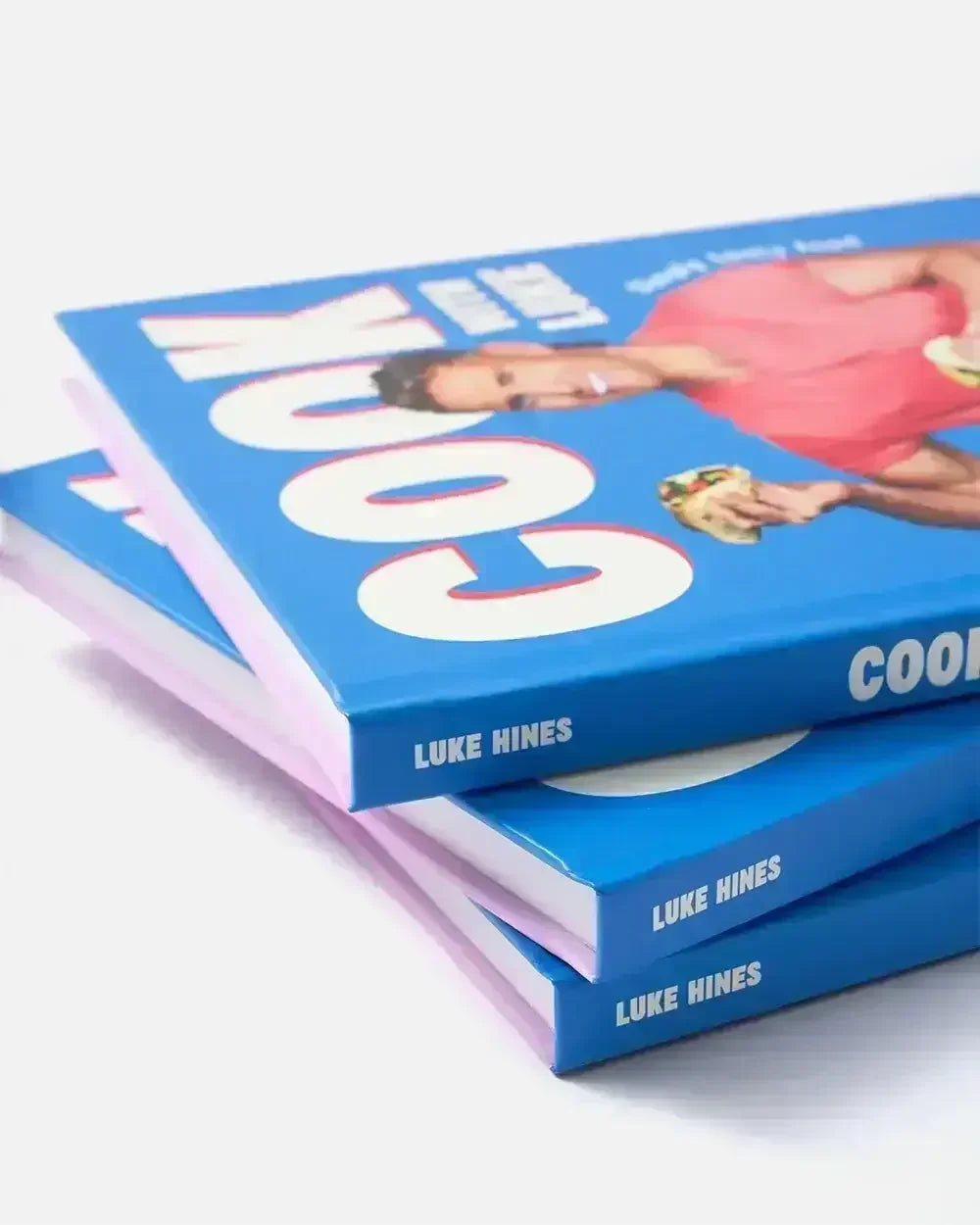 Stack of Luke Hines blue hardcover cookbooks with bold white text on the cover