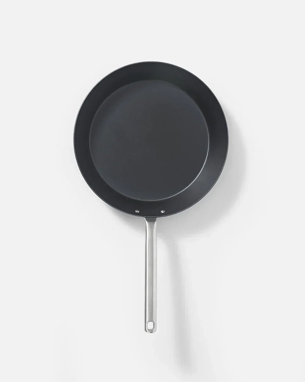 Top view of a black non-stick frying pan with stainless steel handle on white background