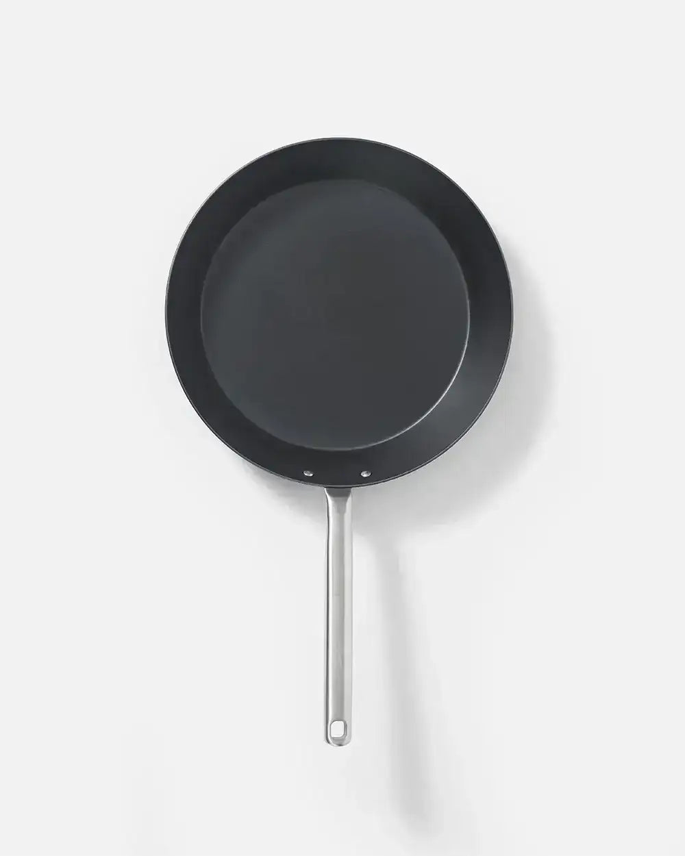 Top view of a black non-stick frying pan with stainless steel handle on white background