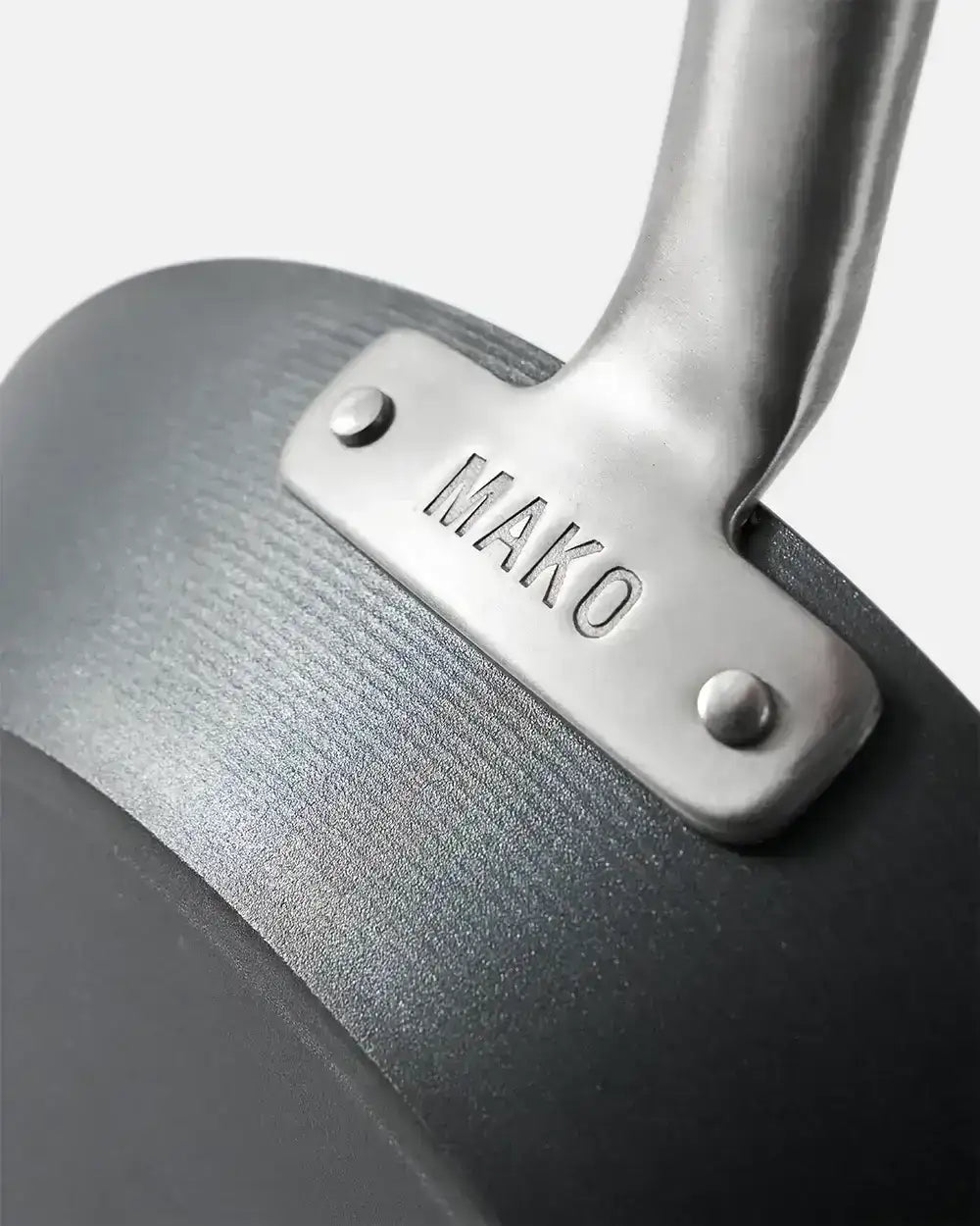 Close-up of black Mako steak pan handle riveted with brushed metal, Marion Grasby cookware