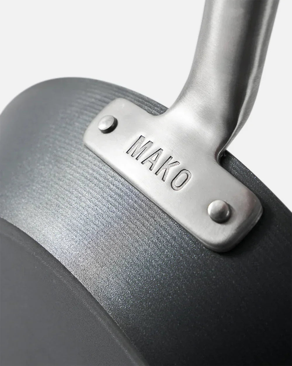 Close-up of black Mako steak pan handle riveted with brushed metal, Marion Grasby cookware
