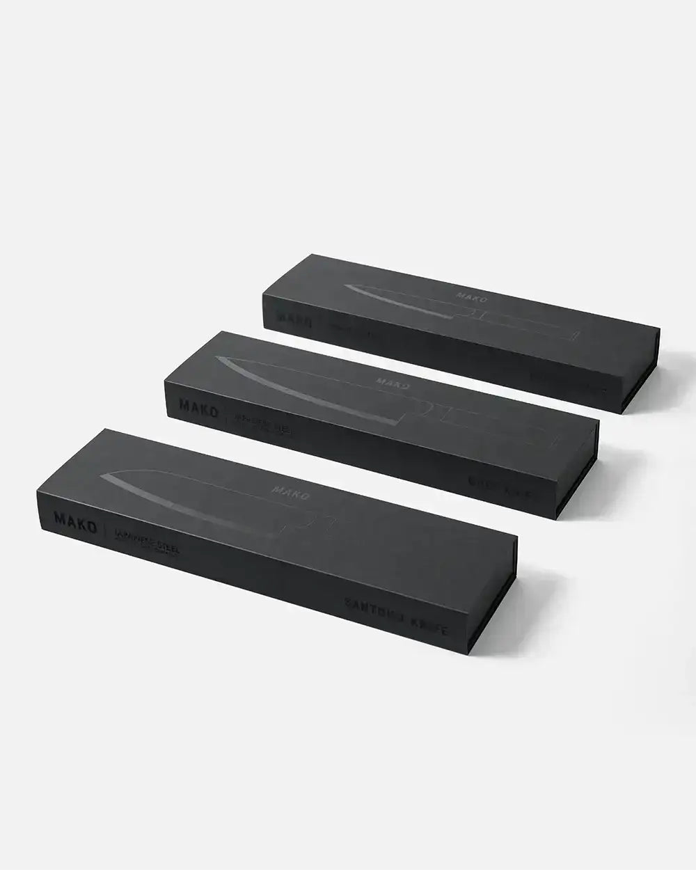 Three black Mako Japanese steel knife boxes for utility, chef, and santoku knives by Marion Grasby