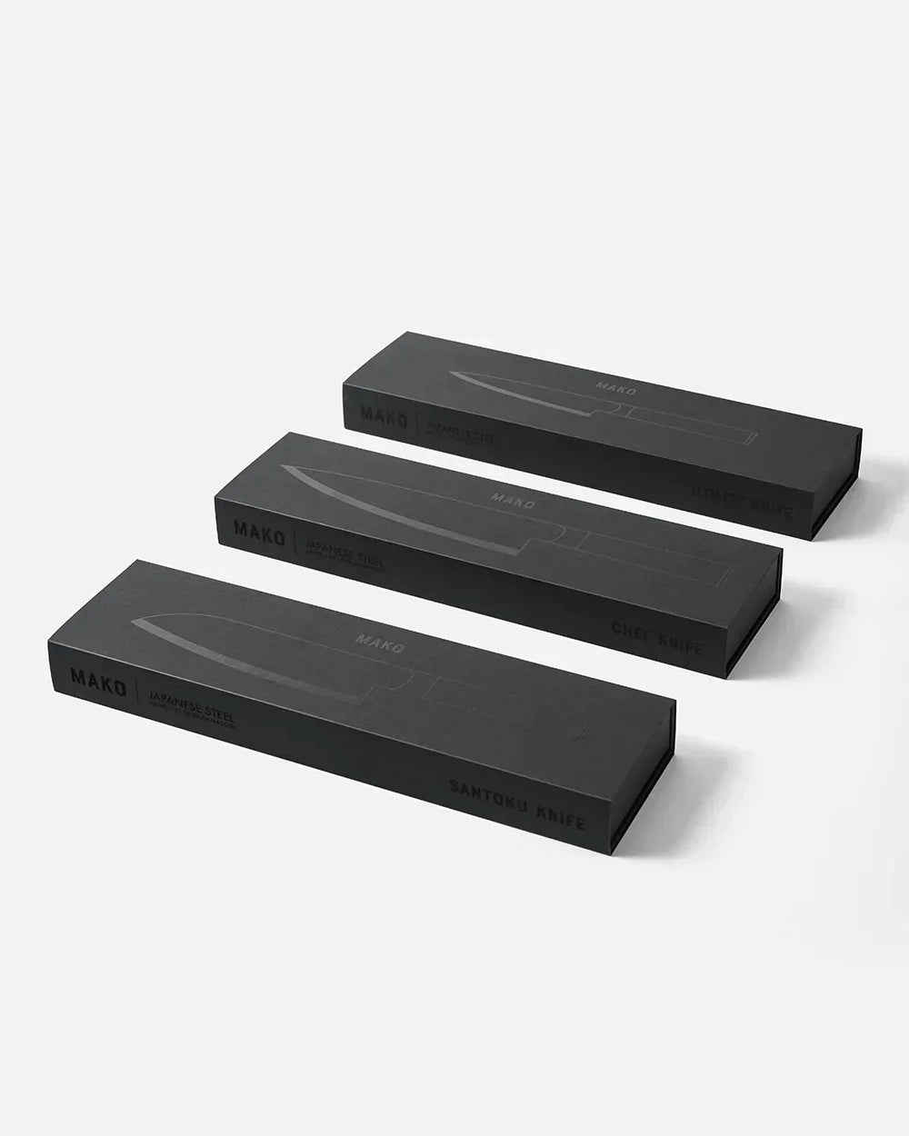 Three black Mako Japanese steel knife boxes for utility, chef, and santoku knives by Marion Grasby