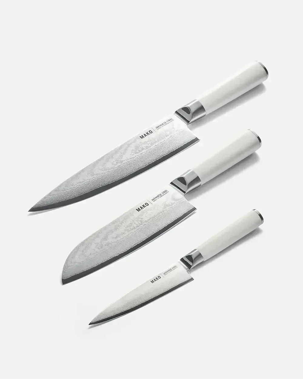 Set of three MAKO Japanese steel kitchen knives with cream handles on white background.