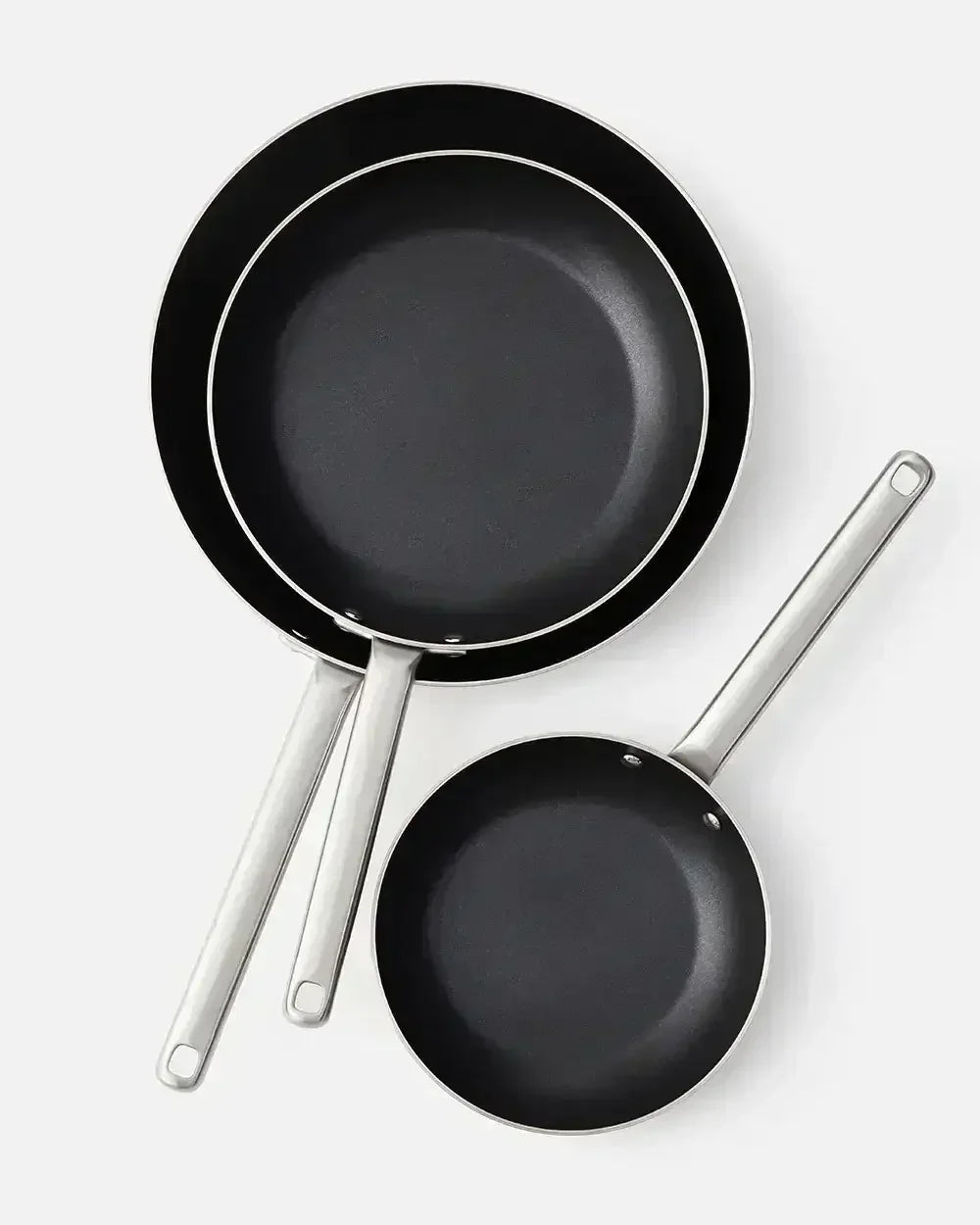Set of three black non-stick frying pans with silver handles on a white background