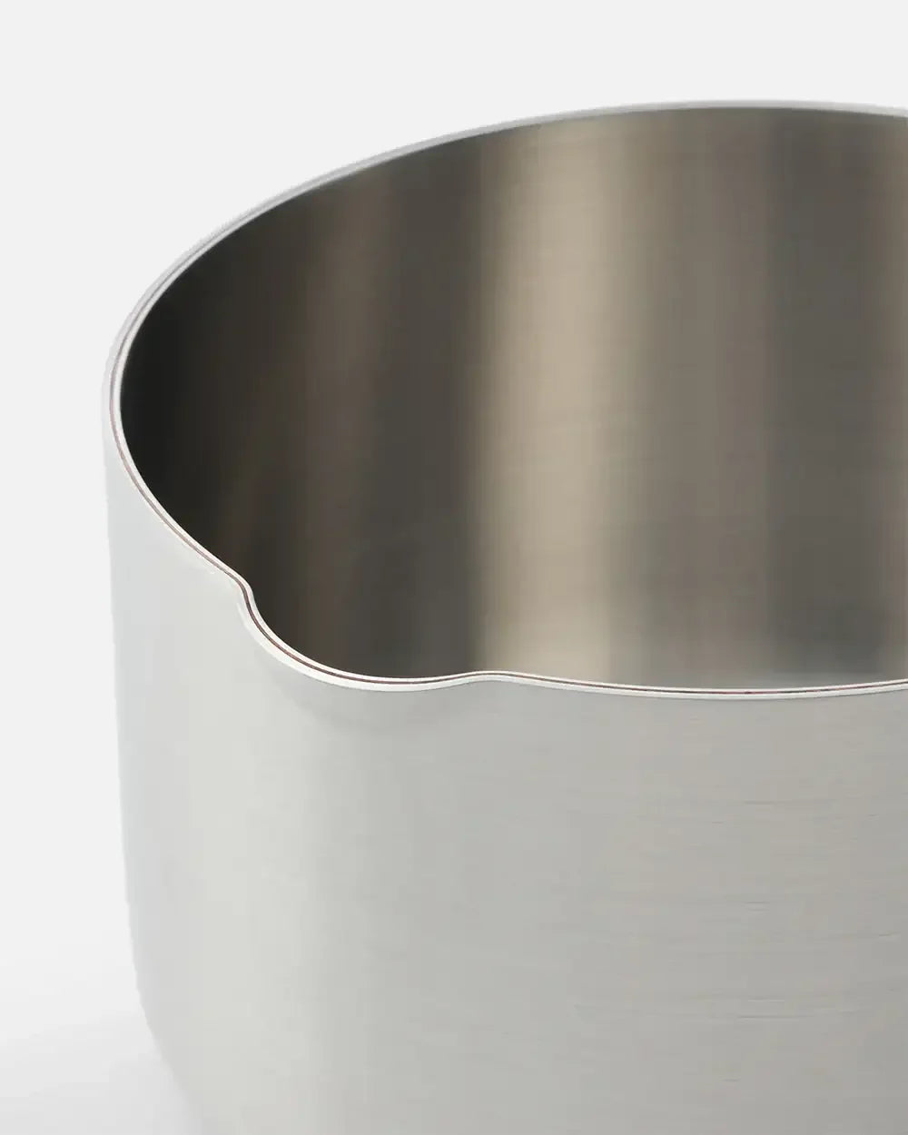 Stainless steel saucepan with rounded edge and pour spout on white background