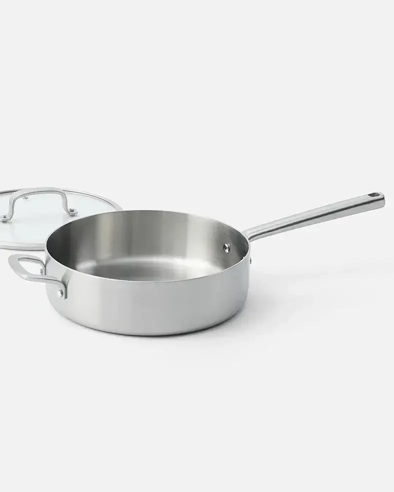 Stainless steel sauté pan with glass lid on white background, cookware kitchen essential
