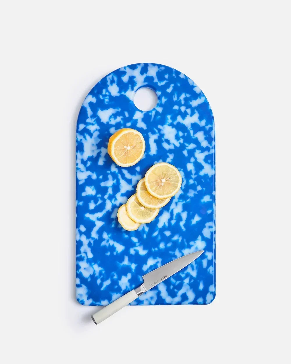 Blue and white marbled Mako cutting board with sliced lemon and a white-handled knife