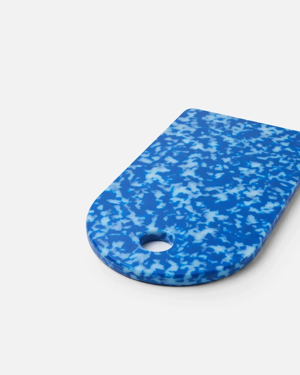 Blue and white speckled rectangular cutting board with rounded edges and a hole