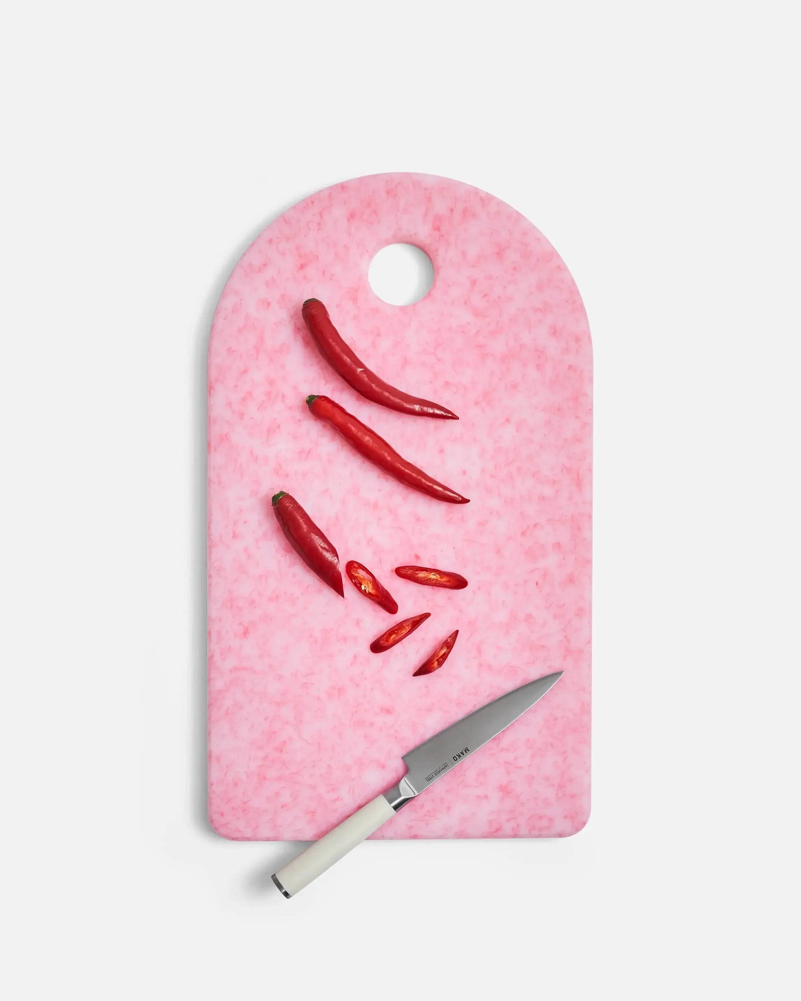 Pink marbled cutting board with sliced red chili peppers and a Mako paring knife by Marion Grasby