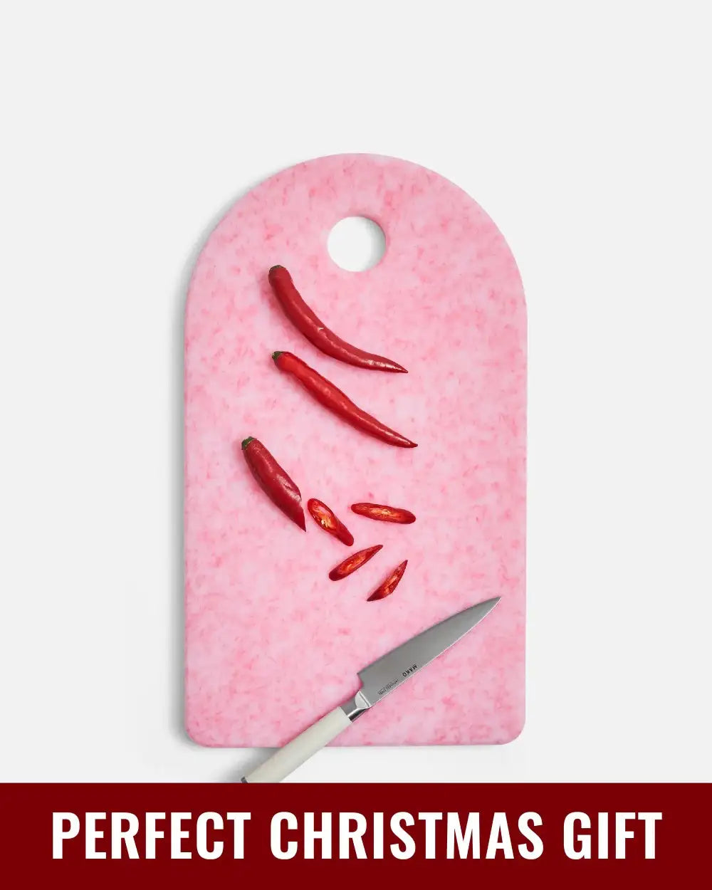 Pink Mako cutting board by Marion Grasby with sliced red chili and white-handled knife
