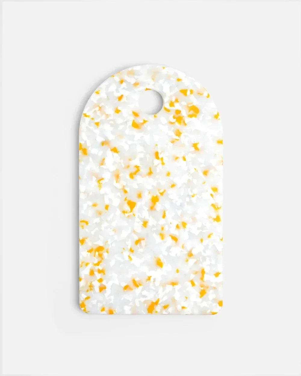 White and lemon yellow speckled cutting board with rounded top and hanging hole